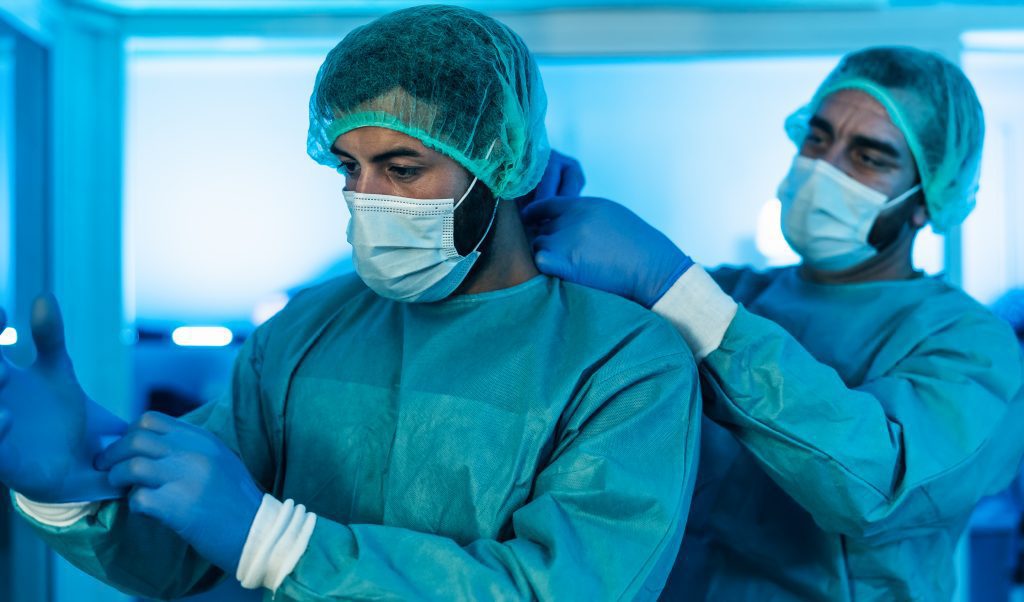 Équipe de chirurgiens souriants préparés pour une opération.