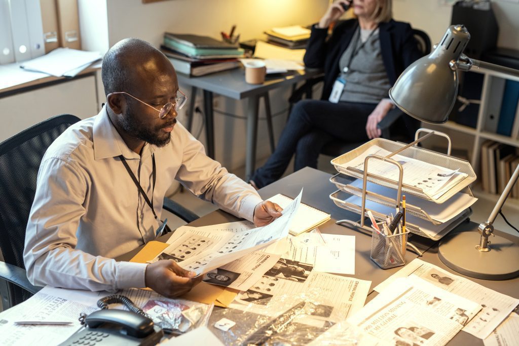Un homme assis à un bureau, lisant attentivement des documents